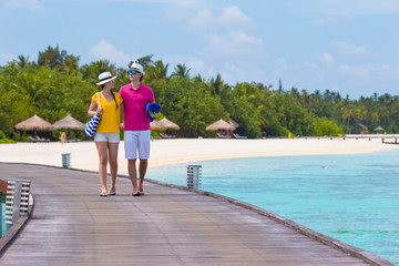Young couple on beach jetty at tropical island in honeymoon