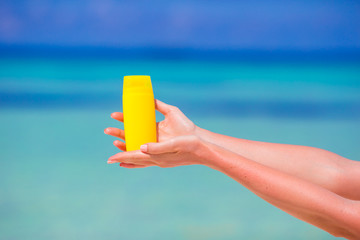 Closeup suncream bottle background blue sea