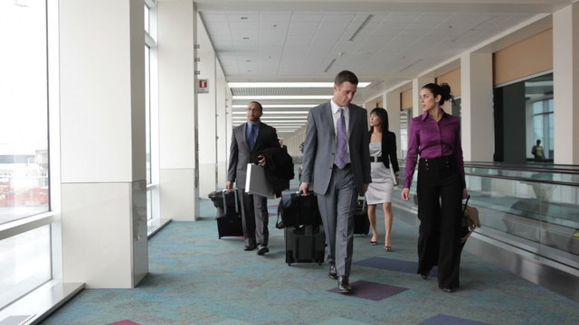 Business people walk through airport lobby