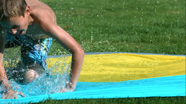 Young boy on water slide in slow motion