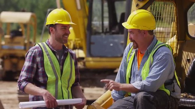 Two Workers Talking Together On Job Site