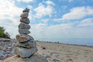 Fototapeta na wymiar Balanced stones stacked to a tower on the beach of the Baltic Se