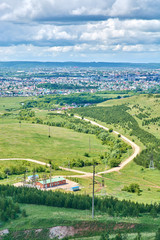 Obraz premium Top view of a country road and the city in the background
