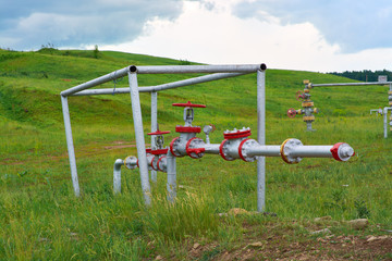 Fototapeta na wymiar Valves on the pipeline at the mouth of the oil well