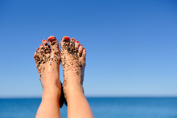 Woman feet closeup of girl relaxing on beach