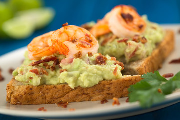 Wholegrain toast bread with guacamole, fried shrimp and bacon