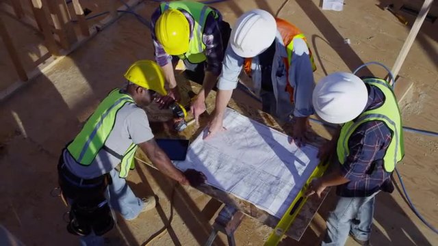 Overhead Shot Of Construction Workers Lookin At Plans