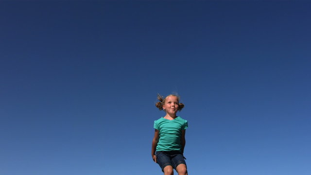 Young girl jumping on trampoline, slow motion
