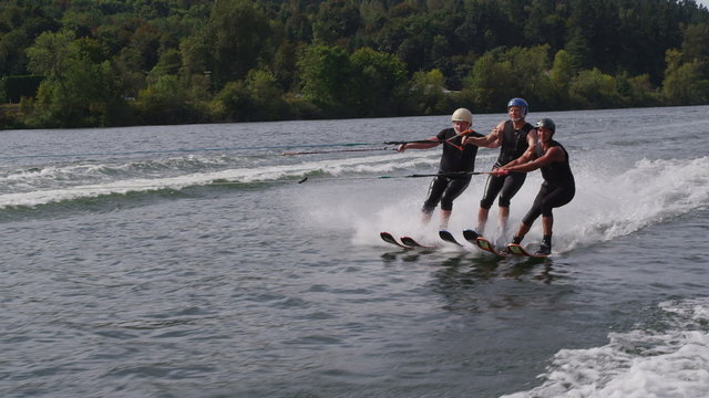 Water skier jumps over teammates, slow motion