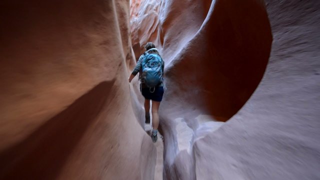 Woman Hiker Backpacker hiking narrow slot canyon
