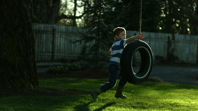 Boy playing on tire swing