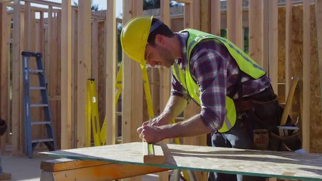 Construction worker preparing to cut board
