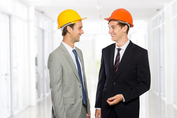 Two young businessman wearing safety helmet