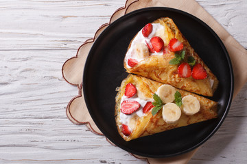 crepes with strawberries and bananas horizontal top view
