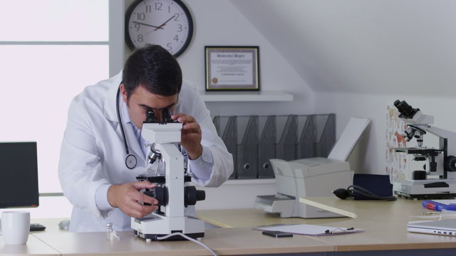 Veterinarian using a microscope in office