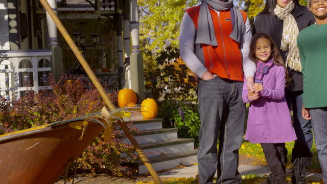 Happy mixed race family playing in autumn leaves