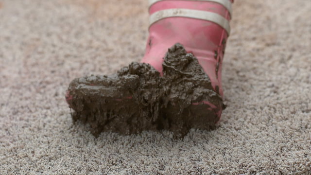 Muddy boot falling onto carpet in slow motion