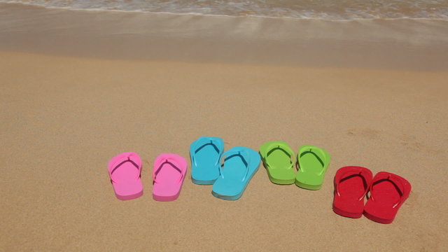 Family's sandals on sandy beach