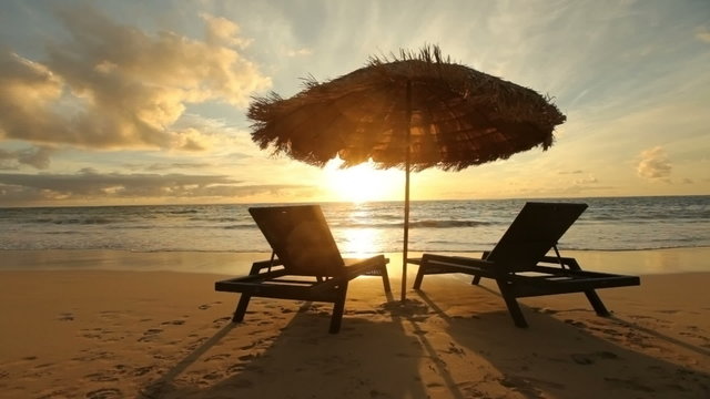 Sunrise at tropical beach with chairs and hut