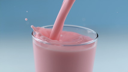 Strawberry milk pouring and splashing in slow motion