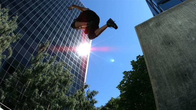 Three free runners jump over camera, slow motion