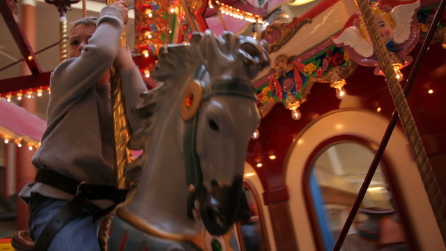 Boy riding on carousel