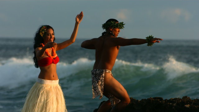 Polynesian dancers perform by ocean, slow motion