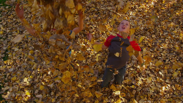 Boys throwing fall leaves