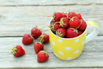 Strawberries berry in cup on grey wooden background