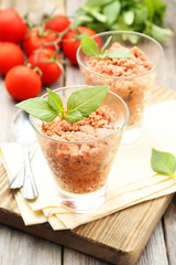 Glass with granita from fresh tomatoes on grey wooden background