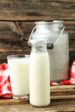 Can and glass of milk on brown wooden background