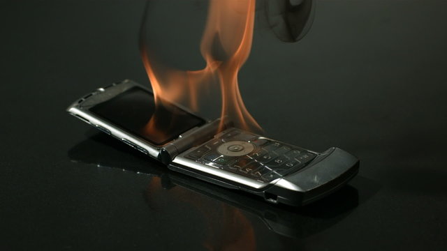 Burning and hitting cell phone with a hammer