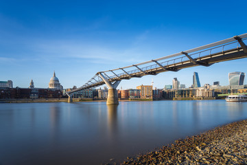 St Paul's Cathedral and Millennium Bridge with Bank district in sunset, London, UK