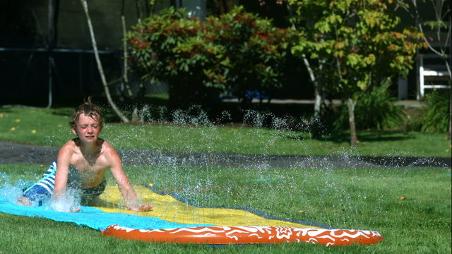 Young boy on water slide in slow motion