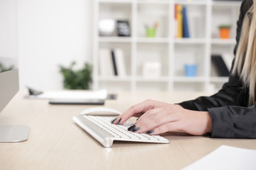 Fototapeta premium Business woman in her mid thirties sits at a desk in front of a computer