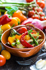 Delicious baked vegetables on a wooden background