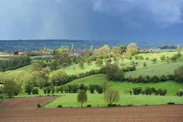 Photo sur Plexiglas Colline Dark rain clouds above a hillside of Pays de Herve, a natural region of Wallonia, Belgium