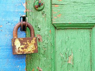 Old metal lock on a wooden door.