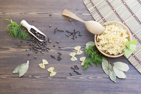 Pasta with herbs and spices on dark wooden table