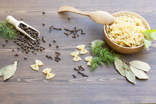 Pasta with herbs and spices on dark wooden table
