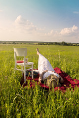 Woman Laying on Red Cloth in Summer Time on Meadow