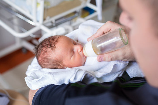 Father Feeding His Tiny Baby Boy In The Hospital