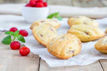 Madeleines cookie with raspberry on parchment paper, closeup