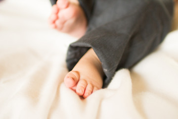 Cute little baby feet on white blanket
