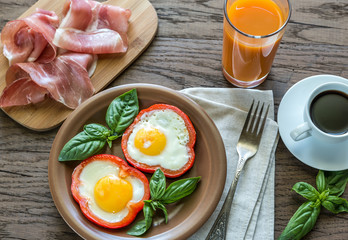 Fried eggs with prosciutto on the wooden table