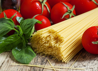 Dry Italian pasta Capellini with tomato and basil, selective foc
