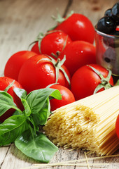 Dry Italian pasta Capellini with tomato and basil, selective foc