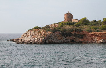 Rocky sea coast and ancient watchtower. Illetes, Palma-de-Majorca, Spain