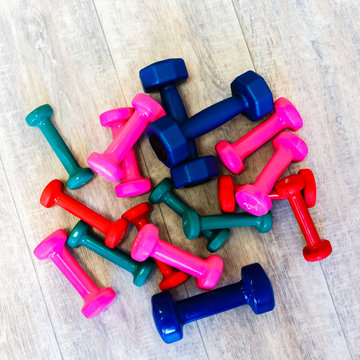 Group of colored dumbbells on the floor in the gym