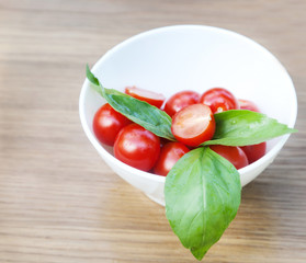 cherry tomatoes, basil and mozzarella cheese on a plate